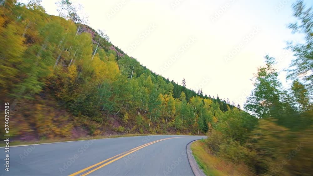 Pov point of view driving in car vehicle at Aspen, Colorado USA Rocky mountains paved road trip with foliage in autumn fall on trees on Castle Creek scenic road with colorful yellow orange leaves Pov point of view driving in car vehicle at Aspen, Colorado USA Rocky mountains paved road trip with foliage in autumn fall on trees on Castle Creek scenic road with colorful yellow orange leaves