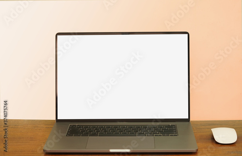 The laptop and the mouse are located on the desk, brown background.