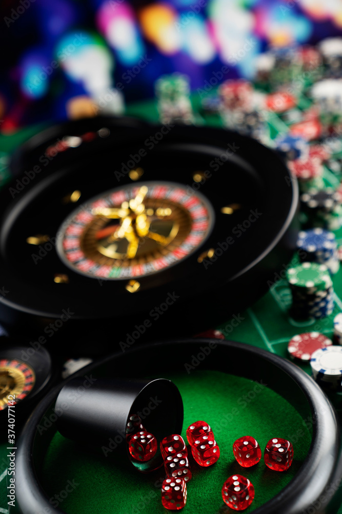 Casino theme, close up of roulette, red and black numbers. Stack of chips in the background. Casino theme, close up of roulette, red and black numbers. Stack of chips in the background.