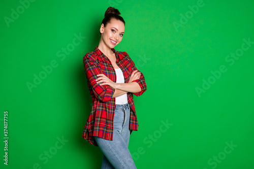 Profile side view portrait of her she nice attractive fashionable lovely cute cheerful sweet content girl in checked shirt folded arms isolated on bright vivid shine vibrant green color background © deagreez