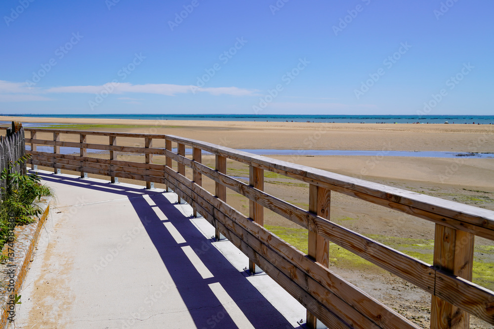 wooden sea access walkway leading to sand beach atlantic ocean horizon in Jard sur Mer in france