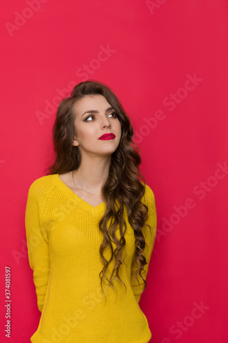 Pensive Young Woman In Yellow Sweater Looks Up
