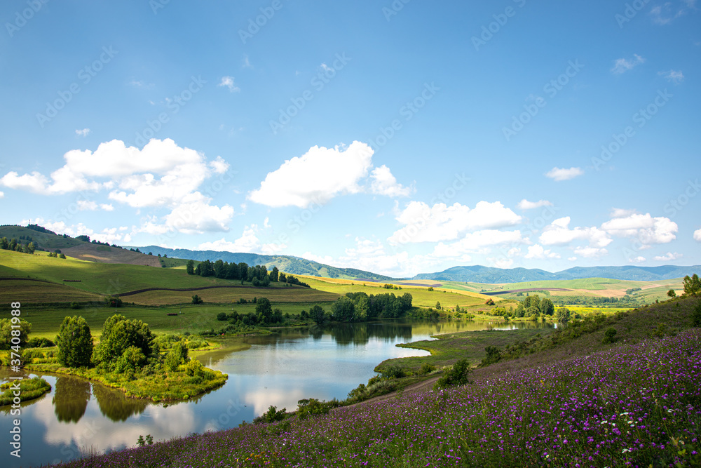 Landscape with hills and lake on a Sunny day, blue sky with clouds. Russia, Altai territory