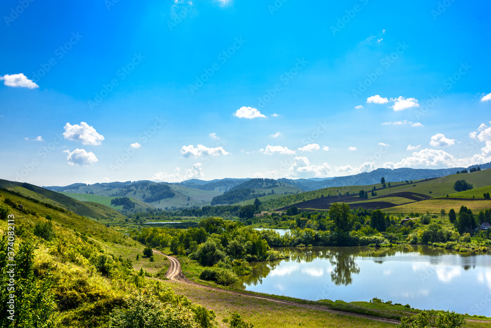 Landscape with hills and lake on a Sunny day, blue sky with clouds. Russia, Altai territory Landscape with hills and lake on a Sunny day, blue sky with clouds. Russia, Altai territory