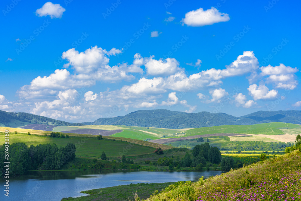 Landscape with hills and lake on a Sunny day, blue sky with clouds. Russia, Altai territory