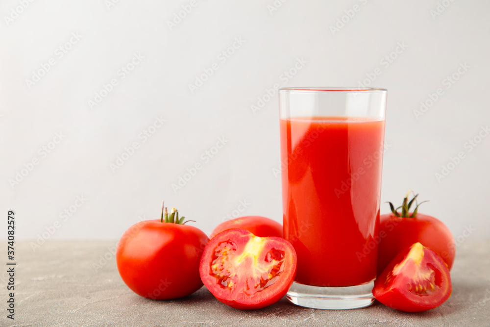 Fresh tomatoes with juice on grey background Fresh tomatoes with juice on grey background