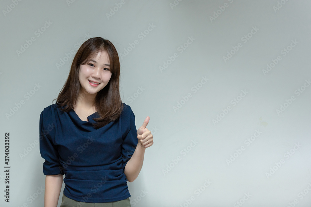 Asian business woman smiling and gesturing on gray background. Asian business woman smiling and gesturing on gray background.