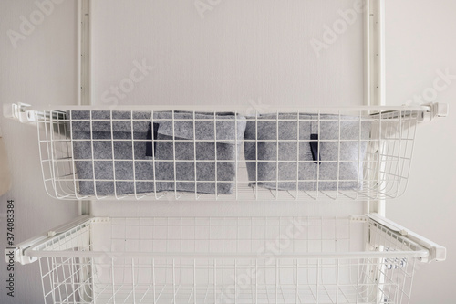 Metal white baskets for wardrobe. Scandinavian minimal smart storage concept. Storage organization concept photo