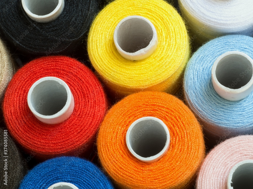Threads of different colors on spools, standing vertically,top view,detail Threads of different colors on spools, standing vertically,top view,detail