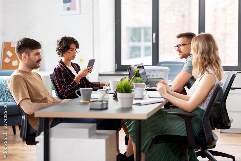 business, people and corporate concept - team of startuppers working at office business, people and corporate concept - team of startuppers working at office