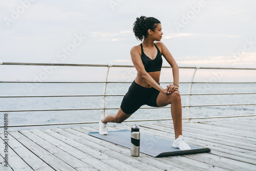 Image of african american sportswoman doing exercise while working out