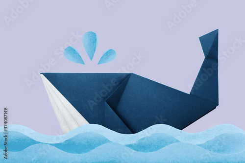 Photo of paper origami marine blue whale in waves on violet background