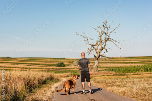 Local Adventures in Pandemic Time. Man with Dog Together in the Middle of Nowhere © marcin jucha