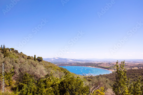 Fototapeta Naklejka Na Ścianę i Meble -  View on the Golfo di Baratti bay on Piombino peninsula from Populonia village. Turquoise water of the sea, marina with boats, italian costal landscape in summer.