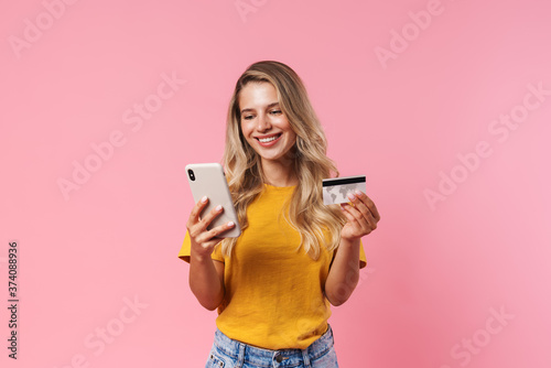 Cheery woman using mobile phone and holding credit card