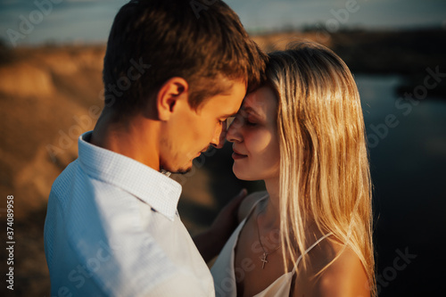 Close up portrait of happy couple in love. Passion couple in love stands against the beautiful landscape.