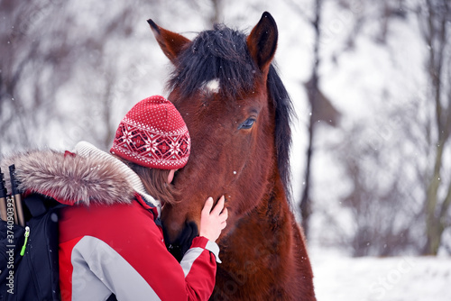 nter photo of a girl and a horse in the winter forest. photo