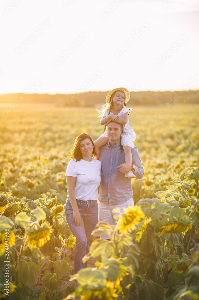 Happy family is playing, having fun on the field with sunflowers at sunset. Happy family is playing, having fun on the field with sunflowers at sunset.