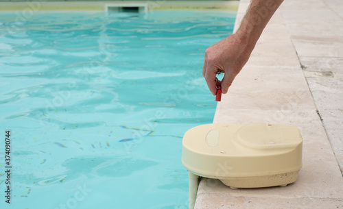 Fotografie mans hand with contact key used to deactivate swimming pool alarm