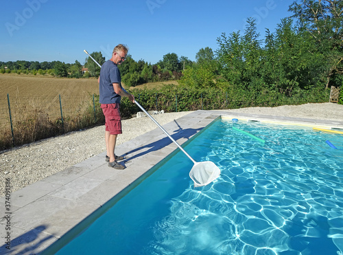 man cleaning a swimming pool with a net
