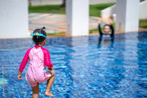 Little girl looking at her mother at swimming pool