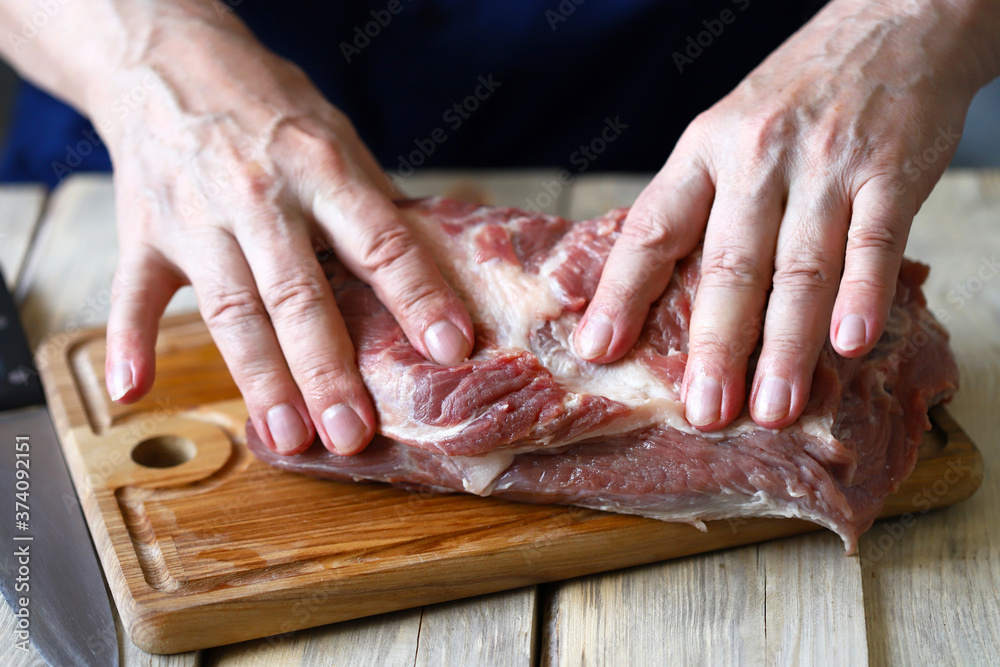 Selective focus. Raw meat in the hands of the chef. Preparing meat for barbecue. Pork neck.