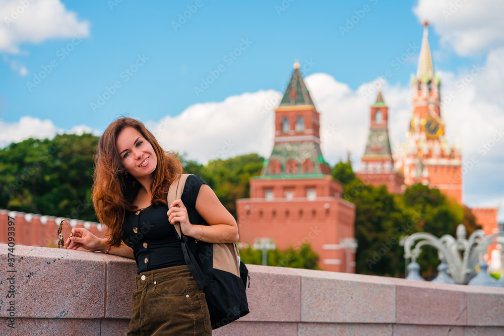 Portrait of a beautiful young female tourist with a view of the Kremlin in Moscow, Russia