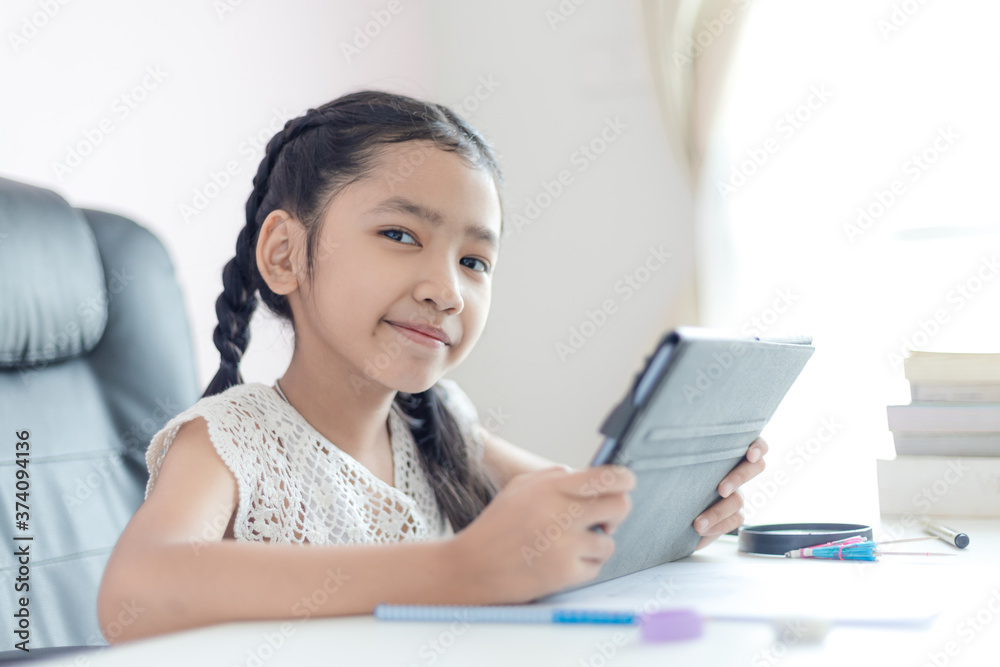 Little Asian girl using tablet and smile with happiness for education concept select focus shallow depth of field Little Asian girl using tablet and smile with happiness for education concept select focus shallow depth of field