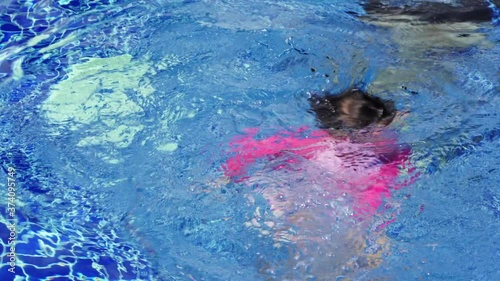 Little girl getting drowning in swimming pool.