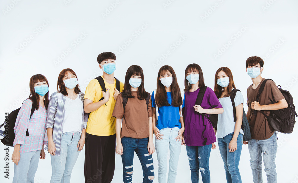 Obraz premium young student group wearing protective medical face masks standing together