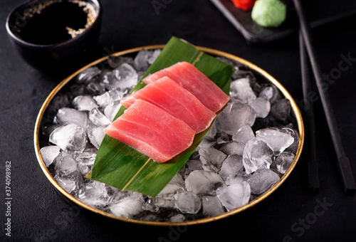 tuna sashimi on ice in a black plate
