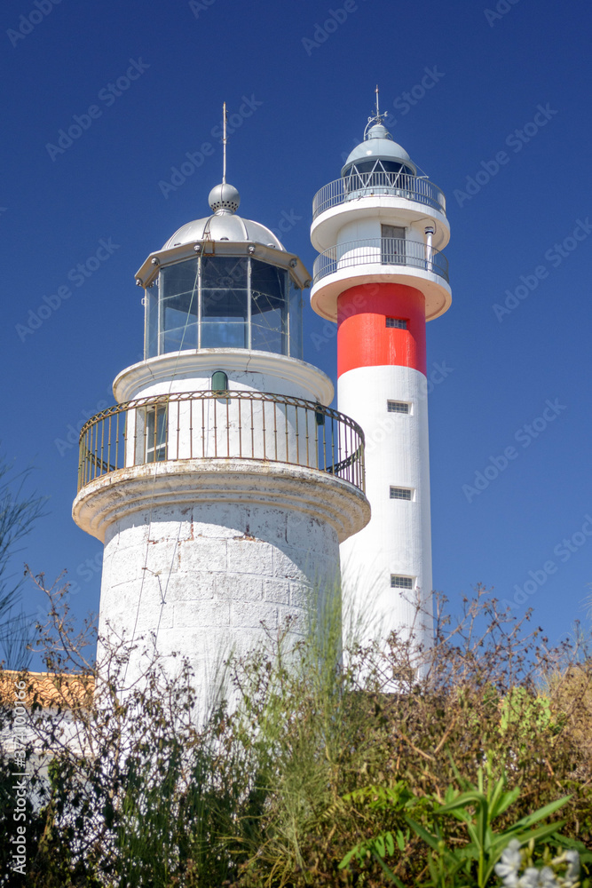 Two lighthouses together on the Spanish coast. The ancient and the modern together. Sunny day in El Rompido, Huelva, Andalusia, Spain Two lighthouses together on the Spanish coast. The ancient and the modern together. Sunny day in El Rompido, Huelva, Andalusia, Spain