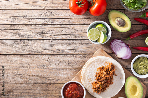 Mexican tacos ingredients on wooden table. Top view.Copy space