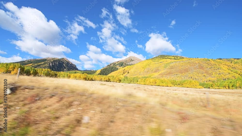 Pov side point of view driving in car at Colorado USA Rocky mountains paved road trip with foliage in sunny autumn fall on aspen trees on Castle Creek scenic road with colorful yellow orange leaves