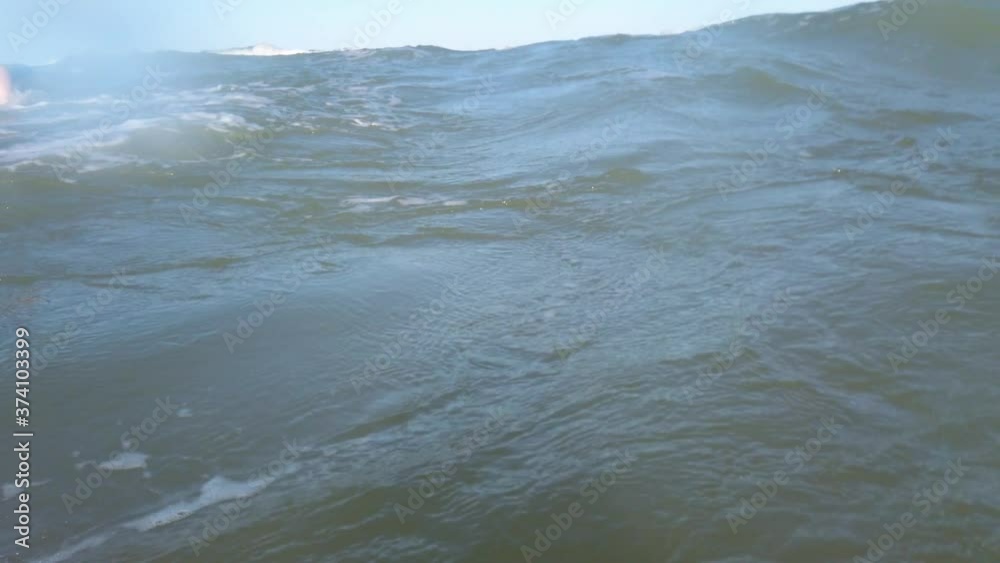 The surfer girl surfing on the surf board on the waves.