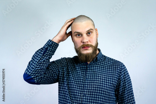 Confused young bald guy with alopecia. man skin head with hair loss want transplant.