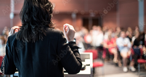 Obraz na plátně Female speaker giving a talk on corporate business conference