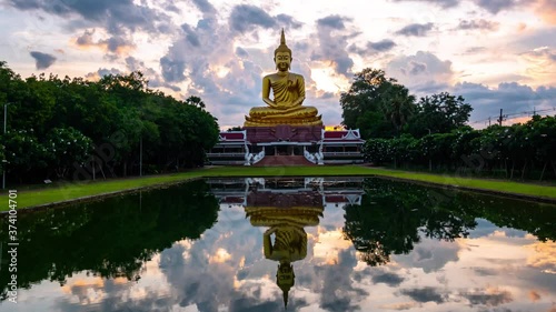 4K:Time lapse Beautiful  Big Golden Buddha statue against sunset clouds sky in Thailand temple,khueang nai District, Ubon Ratchathani province, Thailand.