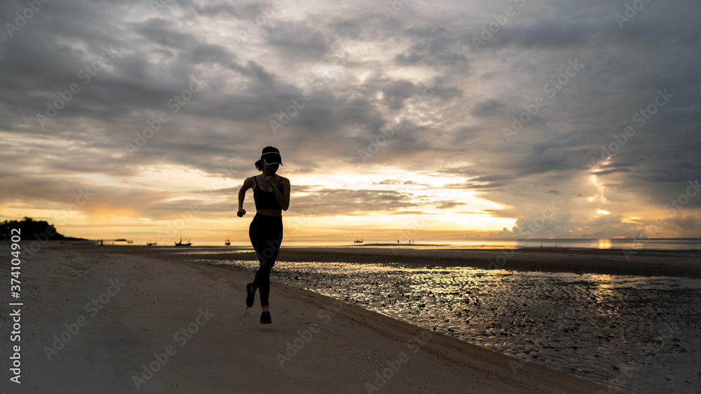 Woman jogging on beach in the morning.