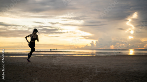 Side view of woman jogging on beach in the morning. © marchsirawit