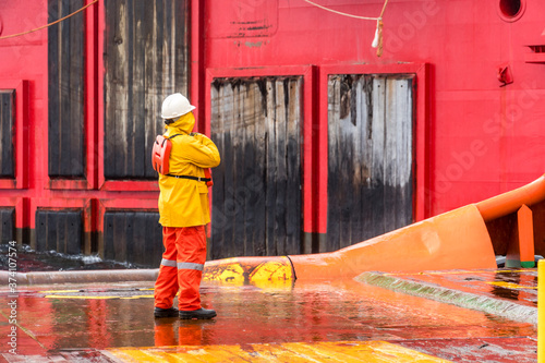 An Able-bodied seamen on anchor handling tug boat communicate with a work barge for receiving material for pipeline installation at Exxonmobil oil field. photo