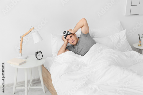 Young man with alarm clock ...