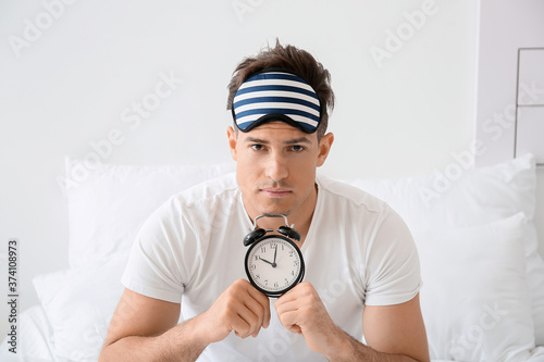 Young man with alarm clock ...
