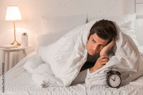Young man with alarm clock ...