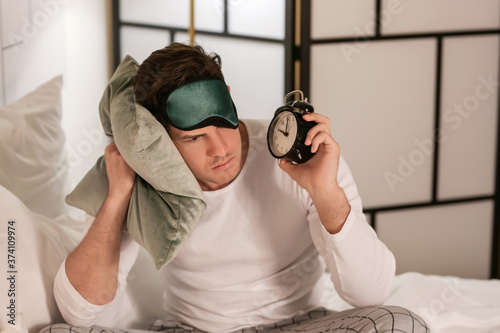 Young man with alarm clock ...