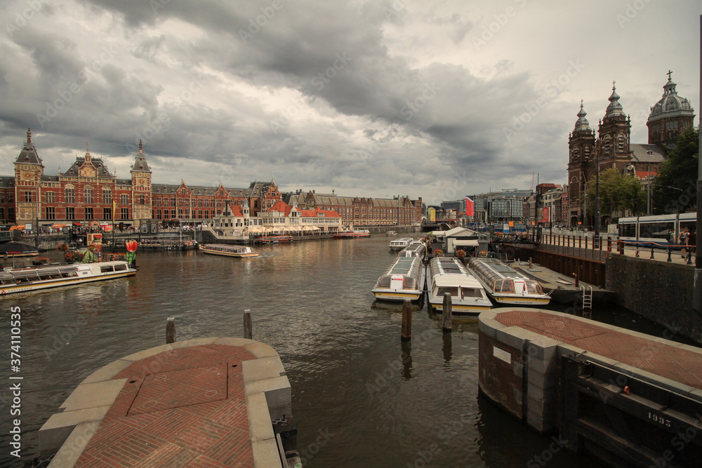 Obraz premium Amsterdam; Openhaven Front mit Centraal Station und St. Nicolaaskerk