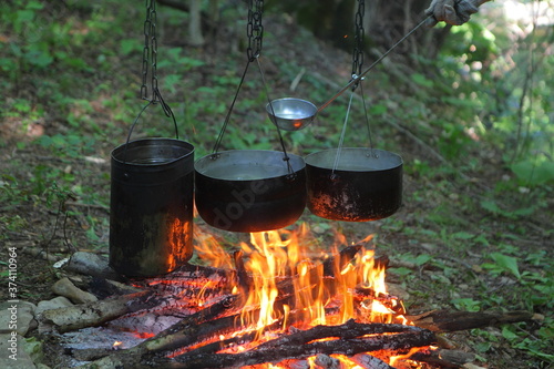 Food is being prepared on a fire in the forest. Hike