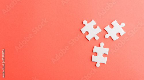 Top view flat lay of three paper plain white jigsaw puzzle game last pieces for solve, studio shot on a red background, quiz calculation concept