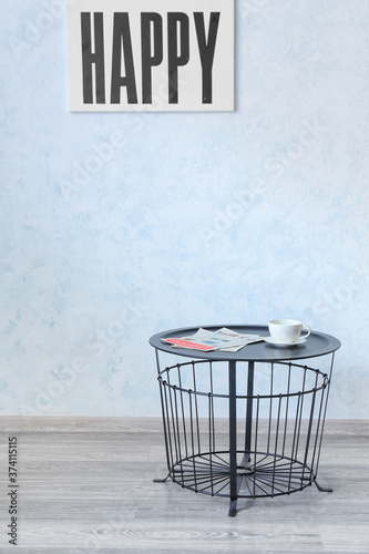 Stylish table near light wall