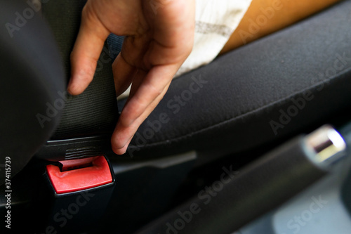 Close-up of a hand fastening a car seat belt. Safety in the car. Seat belt.